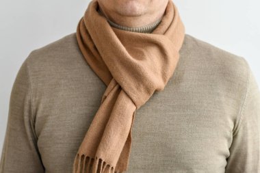 Moda elbisesi, açık bej eşarp ve şık erkek bej süveteri. Seçici odak.