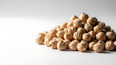 Saf ahşap bir kasede, doğal ışık ve gölgelerle kurutulmuş nohut.