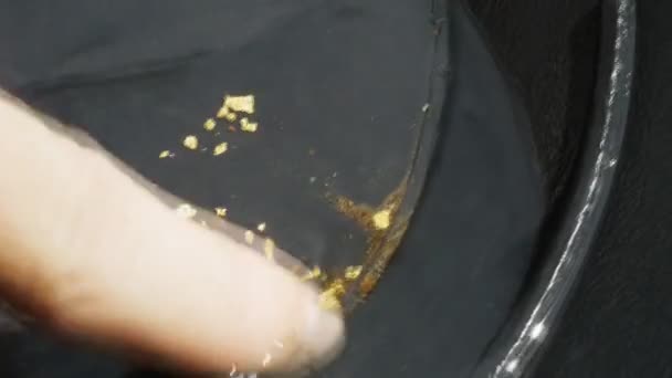 Gouden vlokken in een pan — Stockvideo