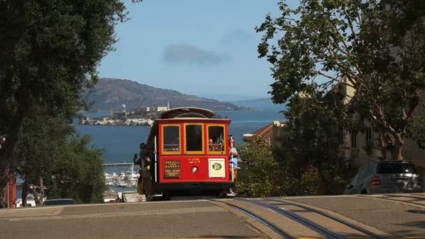 サンフランシスコ カリフォルニア州 アメリカ合衆国 2015 サンフランシスコ カリフォルニアの遠いアルカトラズ島と赤いケーブルカー — ストック動画