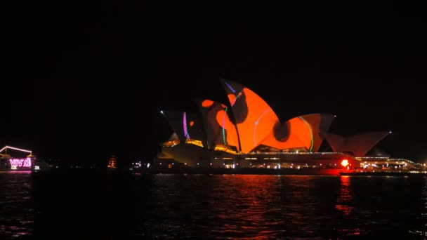 Лодка проплывает мимо ярко освещенного Сиднейского оперного театра — стоковое видео