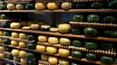 sarı ve yeşil gouda peynirleri satan bir dükkanda.