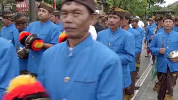BEDUGUL, INDONESIA - MAART, 15, 2018: blauw geklede muzikanten marcheren naar pura danu bratan tempel in bali — Stockvideo
