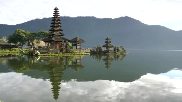 Ранним утром кастрюля храма Пура дану Братан и спокойное озеро на острове Бали — стоковое видео