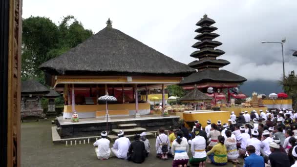 BEDUGUL, INDONESIA MARCH, 15, 2018: Hindu worshipers sit in a courtyard of pura danu bratan temple in bali — стоковое видео