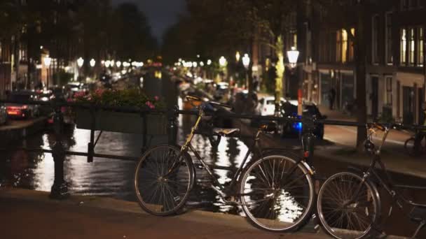 Hollanda 'da Amsterdam' da bir kanalın üzerinde bir bisikletin gece görüntüsü. — Stok video