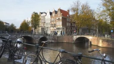 Bisikletlere ve Amsterdam 'da bir kanal köprüsüne doğru yürüyordu.