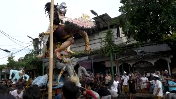 KUTA, INDONÉSIA - MARÇO, 16, 2018: vista lateral de homens hindus movendo uma estátua de ogoh-ogoh em kuta, bali — Vídeo de Stock