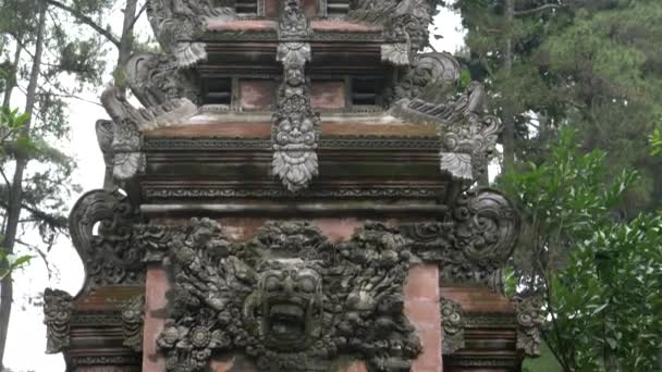 MANUélia, INDONÉSIA-MARÇO, 22, 2018: inclinação para baixo tiro de um portão do templo elaboradamente esculpido no templo tirta empul em bali — Vídeo de Stock