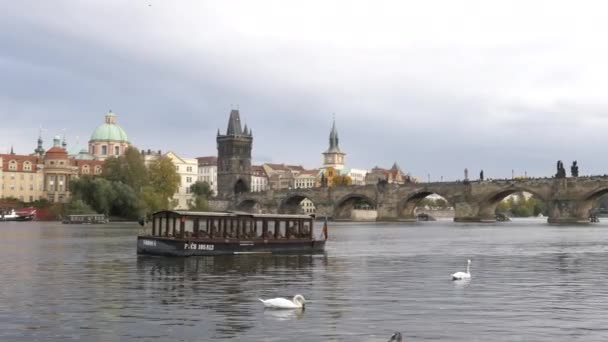 PRAHA, ČESKÁ REPUBLIKA - 10. října 2017: prohlídka lodi s Karlovým mostem v dálce v Praze — Stock video