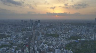Tokyo 'daki Mori Kulesi' nin gözlem güvertesinden 3 shuto ekspres yolunun manzarası bulutların altında batan güneş gibidir.