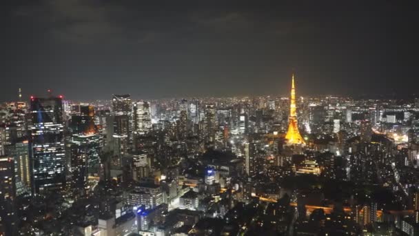 A wide angle pan of tokyo tower at night from the observation deck of the mori tower in tokyo — Stock Video