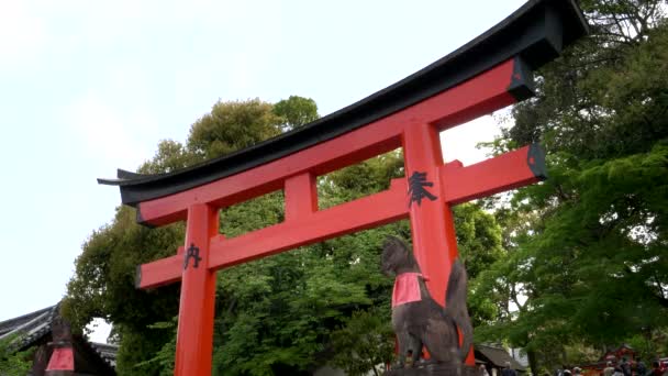 Helig räv staty vid en torii grind i fushimi inari tempel i kyoto — Stockvideo