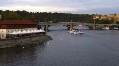 Prag 'daki Charles Köprüsü' nden görüldüğü üzere Vltava Nehri 'nde bir tur teknesi.