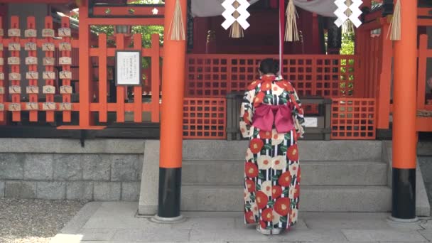 KYOTO, JAPAN - KWIETNIA, 16 KWIETNIA 2018: japońska czcicielka kłaniająca się w świątyni fushimi inari — Wideo stockowe