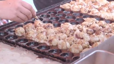 Bir takoyaki satıcısı Kyoto 'da bir tezgahta müşteriye hizmet eder.