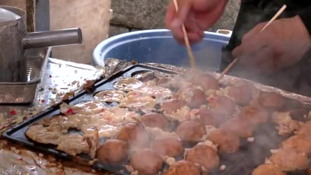 Weitwinkelaufnahme eines Kochs, der Takoyaki an einem Stand in Kyoto dreht — Stockvideo