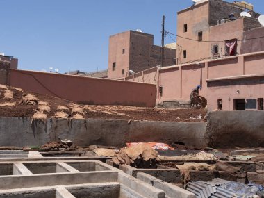 MARRAKESH, MOROCCO- HAZİRAN, 10, 2019: Marakeş 'teki antik tabakhanelerden birinde derileri kurutan işçi