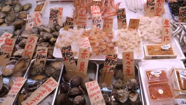 京都の錦市場の様々な魚介類に覆われたテーブルの正面図 — ストック動画