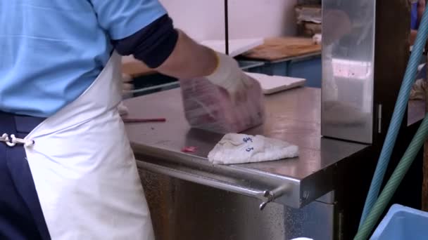 Arbeiter schneiden gefrorenen Thunfisch auf dem Tsukiji-Fischmarkt in Tokio mit einer elektrischen Säge in kleinere Portionen — Stockvideo