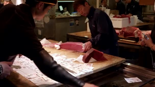 TOKYO, JAPAN - APRIL, 19, 2018: werknemers bereiden de dagorders van verse rauwe tonijn voor op de tsukiji-markt in tokyo — Stockvideo