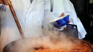 Tsukiji balık pazarında sığır bağırsağından yapılmış et yahnisi servis eden bir şefe yaklaş.