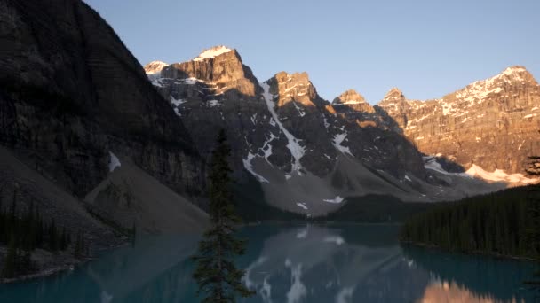 Toma del amanecer de un tranquilo lago de morrena en el parque nacional Banff — Vídeos de Stock