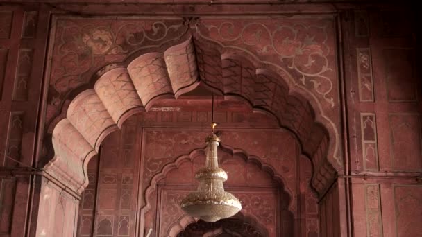 DELHI, INDIA - 11 de marzo de 2019: una gran inclinación hacia abajo de una lámpara de araña y visitantes en jama masjid — Vídeo de stock