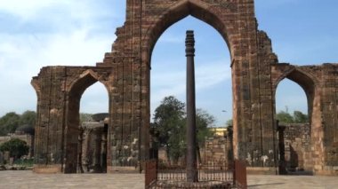 DELHI, Hindistan - 12 Mart 2019: Delhi, Hindistan 'daki Qutub Minar' daki antik demir sütuna doğru yürüyorum