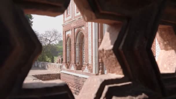 DELHI, INDIA - 12 DE MARZO DE 2019: frente a alai darwaza enmarcado por una ventana de piedra en el complejo minar de la bañera — Vídeo de stock