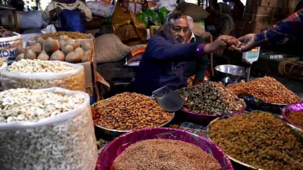 En säljare som säljer mandel på kryddmarknaden i gamla Delhi — Stockvideo