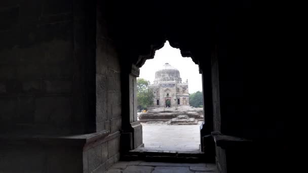 Clip de gimbal caminando hacia shish gumbad enmarcado por un arco en Delhi — Vídeos de Stock