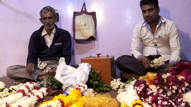 DELHI, INDIEN - 12. MÄRZ 2019: Zwei männliche Arbeiter fertigen Blumengirlanden am alten Delta in Indien — Stockvideo
