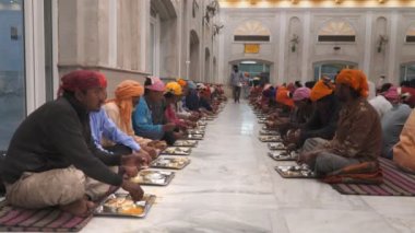 DELHI, INDIA - 13 Mart 2019: Yeni Delhi 'deki Gurudwara Bangla Sahib Langar Hall' da yemek yiyen insanlar