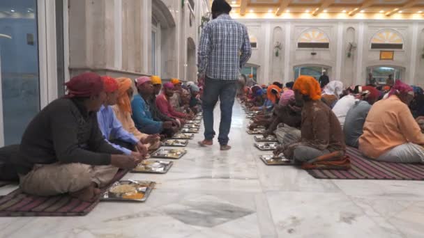 DELHI, INDIA - MARCH 13, 2019: відвідувачі, що їдять у їдальні гурудвара бангла в Делі. — стокове відео