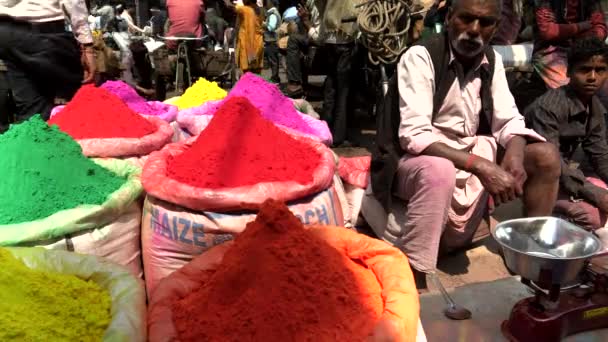 DELHI, INDIA - MARS 14, 2019: närbild av försäljare som väntar bredvid påsar med holi pulver på kryddmarknaden — Stockvideo