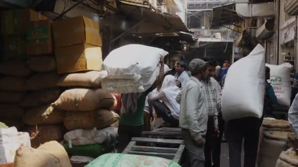 DELHI, INDIA - MARS 14, 2019: 4K 60p klipp med portmonnäer som bär kryddpåsar på kryddmarknaden — Stockvideo