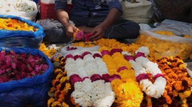 Delhi 'deki baharat pazarında çelenk yapan bir işçiye yakın çekim. 4K 60p.