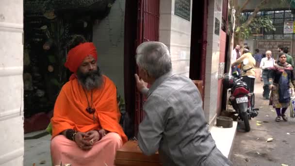 DELHI, INDIA - MARS 14, 2019: Hinduisk helig man och en äldre indian vid gamla delhi, india — Stockvideo