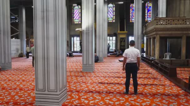 ISTANBUL, TURKEY - MAY, 21, 2019: поклонник стає на коліна і молиться всередині синьої мечеті істанбу. — стокове відео