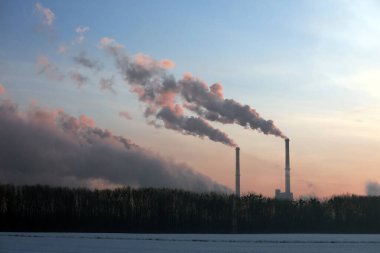 Kışın gün doğumunda fabrikadan buhar çıkıyor. .