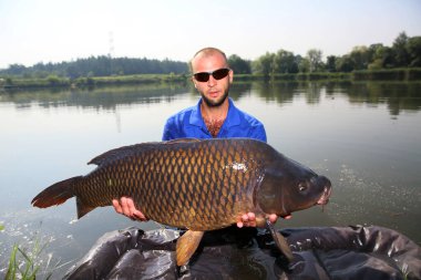 Balıkçı büyük bir sazan balığı yakaladı. 