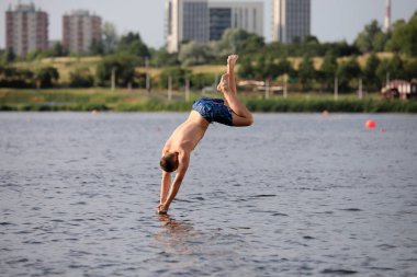Güneşli bir günde genç bir adam suya atlıyor. .