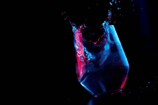 Blaues Und Rotes Wasser Spritzt Einen Glaskelch Auf Schwarzem Hintergrund — Stockfoto