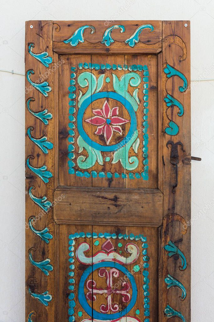 Close up view of old, traditional, wooden door. Colorfully painting reflects Aegean and Mediterranean cultures captured in famous, touristic Aegean town called 