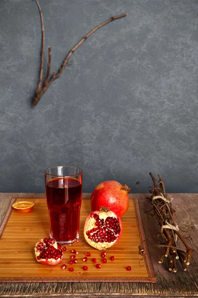 Pomegranate juice with pomegranates and Vine branches — Stock Photo, Image