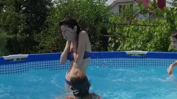Plavecký bazén. Mladá žena a děti si hrají v bazénu. Zpomalený pohyb. HD