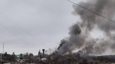 Rus insansız hava aracının Ukrayna 'daki bir şehri bombalaması sonrasında yoğun siyah dumanla yanan sanayi bölgesi savaş hasarı, yıkım ve çevresel etkileri gösteriyor..