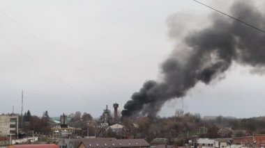 Rus insansız hava aracının Ukrayna 'daki bir şehri bombalaması sonrasında yoğun siyah dumanla yanan sanayi bölgesi savaş hasarı, yıkım ve çevresel etkileri gösteriyor..