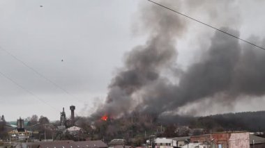 Rus insansız hava aracının Ukrayna 'daki bir şehri bombalaması sonrasında yoğun siyah dumanla yanan sanayi bölgesi savaş hasarı, yıkım ve çevresel etkileri gösteriyor..